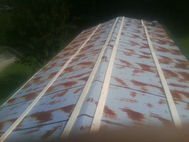 Rusted metal roof panels with new wood purlins before replacement — Storm Damage Roof Repair in Hadley by Roofing Brothers