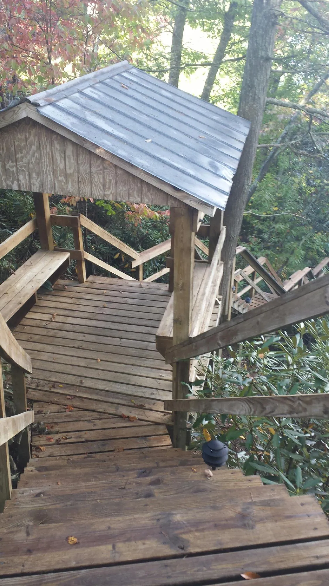 Metal roofed shelter over wooden steps on a wooded walkway — Skylight Repair & Installation work by our crew in Hadley