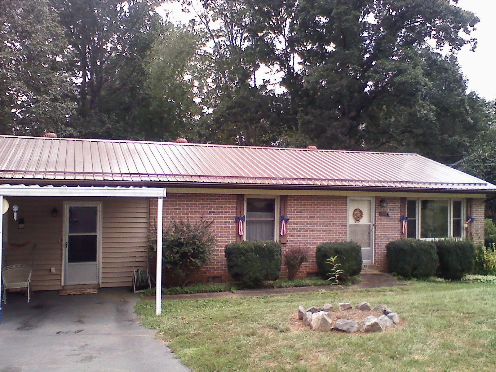 Bronze metal roof and carport on a brick ranch home — Roof Repair work by our crew in Hadley